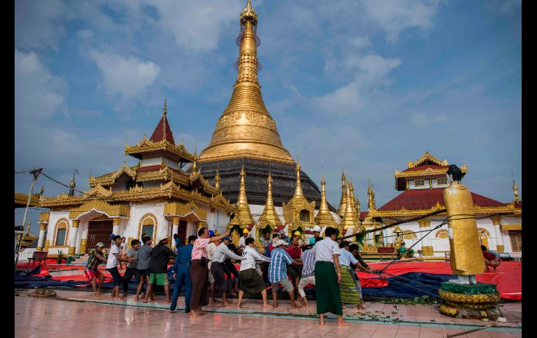 Trabajadores rescatan una estatua de Buda luego de un deslave que afectó una pagoda en Mawlamyine, Birmania. AFP/Y. Aung