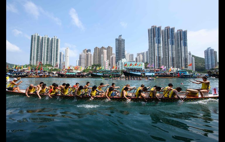 Competidores participan en la carrera anual de botes por el festival 