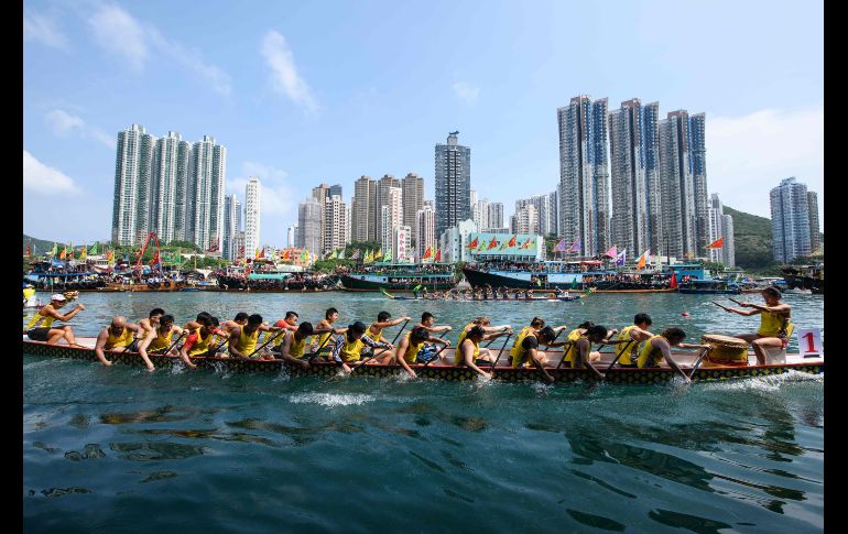 Competidores participan en la carrera anual de botes por el festival 