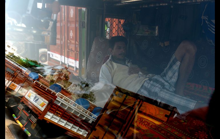 Un chofer de un camión toma una siesta durante una huelga nacional de transportistas en Chennai, India. Los inconformes protestan por el incremento en los precios del combustible. AFP/A. Sankar