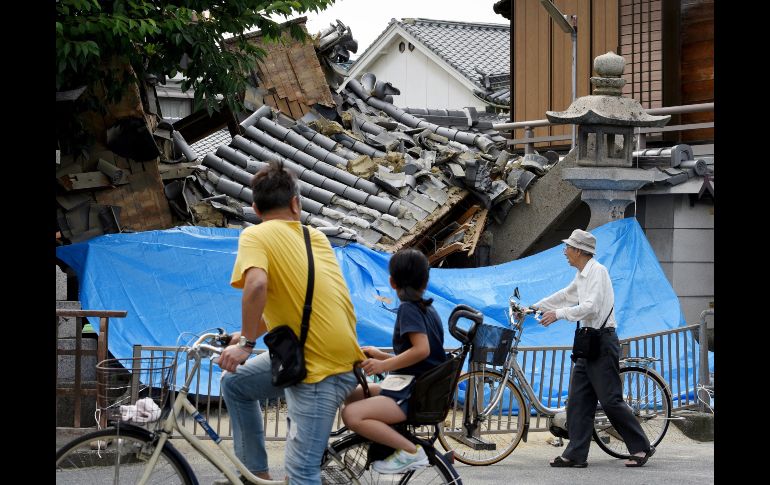 Vecinos de la localidad de Takatsuki observan los daños provocados en un templo.