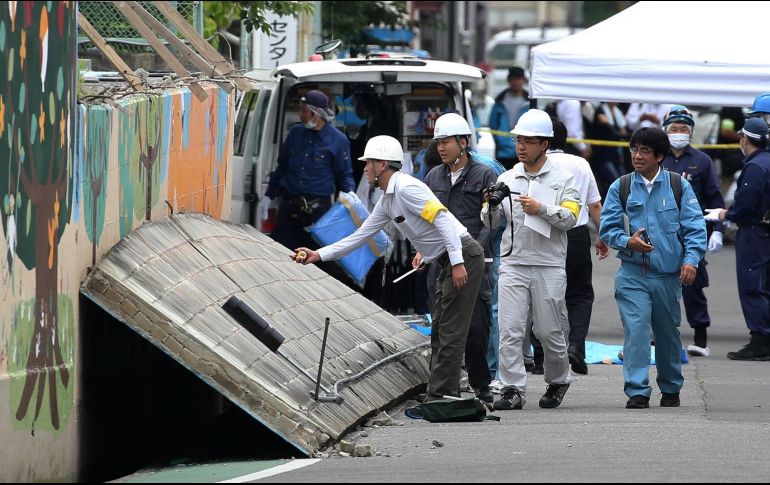 Investigadores de la policía comprueban el muro que cayó sobre una niña en la escuela de primaria de Takatsuki, en el distrito de Osaka, Japón; la pequeña murió. EFE / Jiji Press