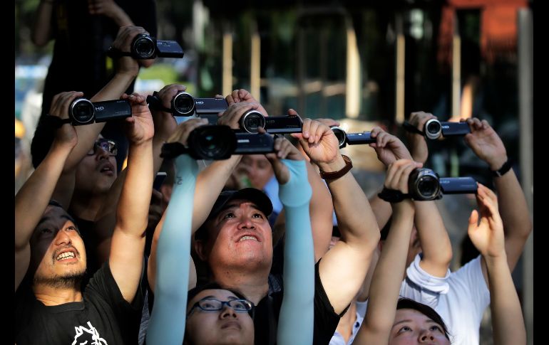 Periodistas filman el convoy que presuntamente traslada al líder norcoreano Kim Jong-Un en Pekín, China. AP/A. Wong