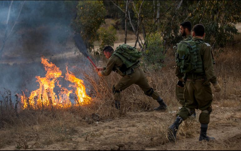 Soldados israelíes extinguen un incendio en la frontera ocasionado por un proyectil lanzado desde Gaza. AP/T. Abayov