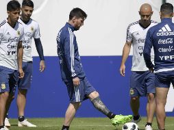 Lionel Messi (C) controla el balón mientras Javier Mascherano (2d), Maximiliano Meza (i) y Ever Banega lo observan, durante los ejercicios matinales de hoy. AFP/J. Mabromata