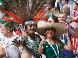 Emplumado. Un mexicano vestido de azteca posa con otra aficionada tricolor en medio de fanáticos de Corea del Sur en Rostov. AFP