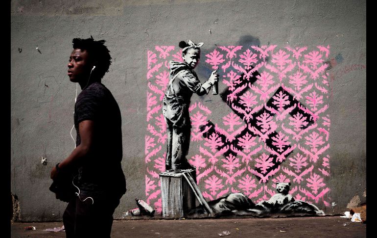 Una obra presuntamente del artista callejero Banksy que ha aparecido hace unos días en París, Francia. La pieza, que muestra a una niña negra que intenta ocultar una esvástica con un mosaico de flores, alude a la crisis de refugiados. AFP/P. Lopez