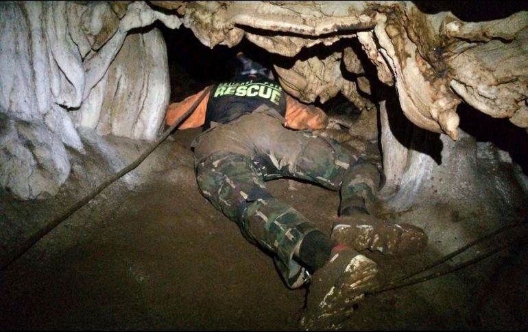 Un miembro de los equipos de rescate se arrastra para tratar de encontrar entradas alternas en la gruta, de unos 10 kilómetros de largo. AP