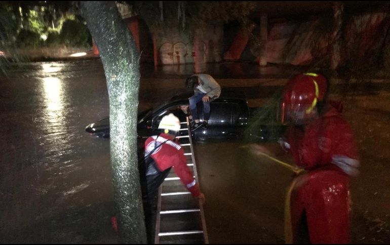 Personal de la dependencia auxilia a una pareja que quedó atrapada en un automóvil varado en una inundación por la tormenta. TWITTER / @UMPCyBZ
