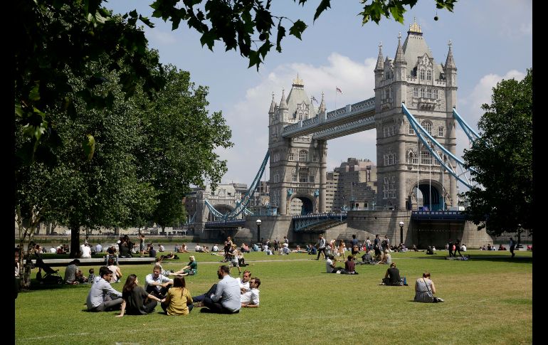 Personas se relajan en un parque junto al río Támesis y con el Puente de la Torre al fondo en Londres. AP/M. Dunham