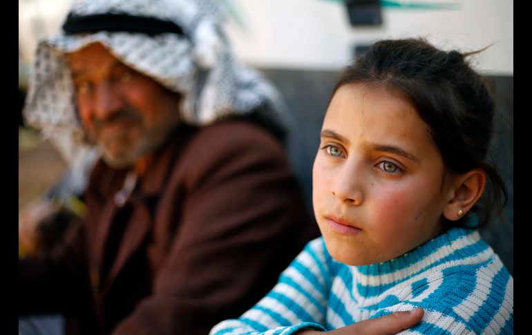Mohammed Suleiman Darwish y su nieta Israa aguardan para cruzar a Siria desde la fronteriza Arsal, en Líbano. Ellos forman parte de un masivo retorno de refugiados sirios a su país desde el Líbano. AP/B. Hussein