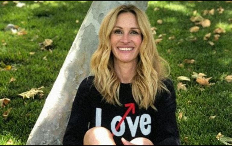 Roberts aparece en la foto sentada en el pasto con pantalones cortos y iuna camiseta negra manga larga. INSTAGRAM / @juliaroberts