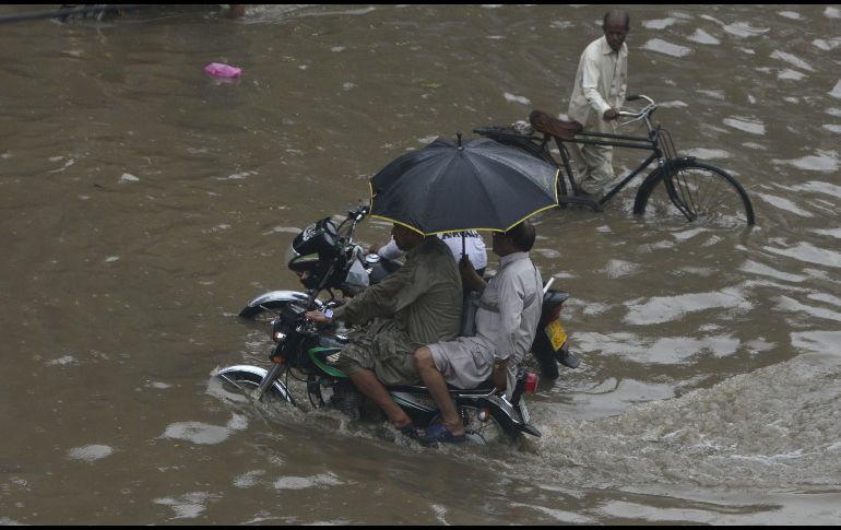 Motociclistas circulan por una calle inundada tras fuertes lluvias en Lahore, Pakistán. AFP/A. Ali