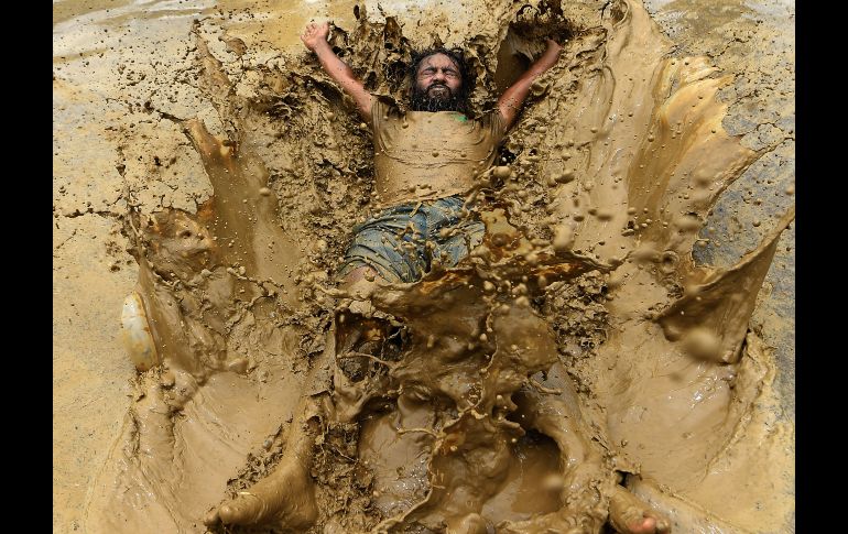 Un joven juega en un campo de arroz en la población nepalí de Lele. Campesinos celebran el Día nacional del arrozal en el arranque de la temporada de siembra. AFP/P. Mathema