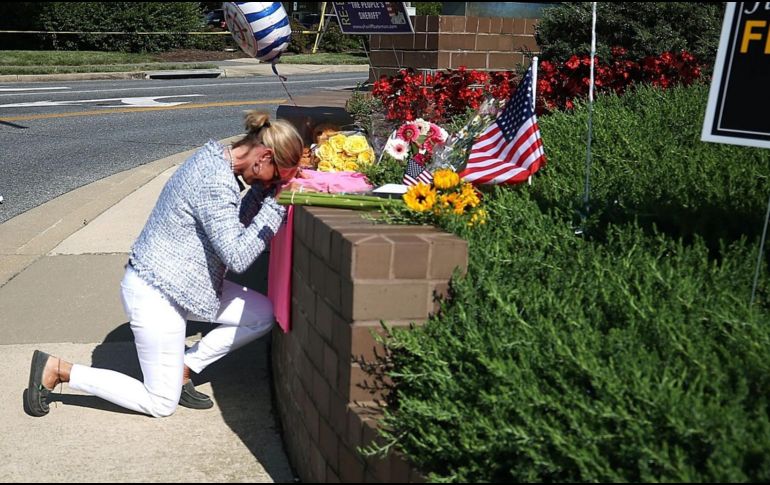 Una mujer deposita ofrendas en un memorial, carca de Capital Gazette, en Annapolis. AFP/M. Wilson