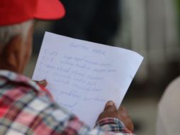 Dentro de la escuela, dos hombres con gorras rojas y playeras blancas, sentados en una de las jardineras, anotaban a mano nombres de ciudadanos EL INFORMADOR/ F. Jaramillo