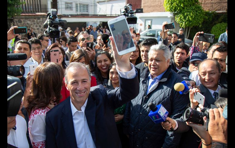El candidato priista José Antonio Meade vota mientras muestra su celular, conectado en videollamada con su padre, en Ciudad de México.