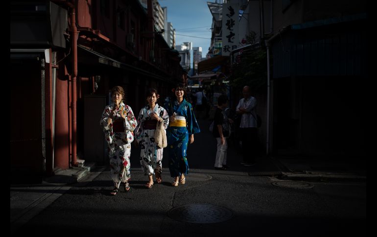 Mujeres en kimonos caminan por una calle del distrito Asakusa en Tokio, Japón. AFP/M. Bureau