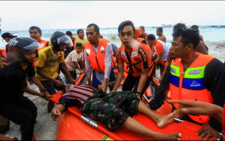 Varios miembros del personal de rescate de Indonesia evacuan a una víctima del naufragio de una embarcación en la costa de la isla Selayar. EFE/M. Syahril