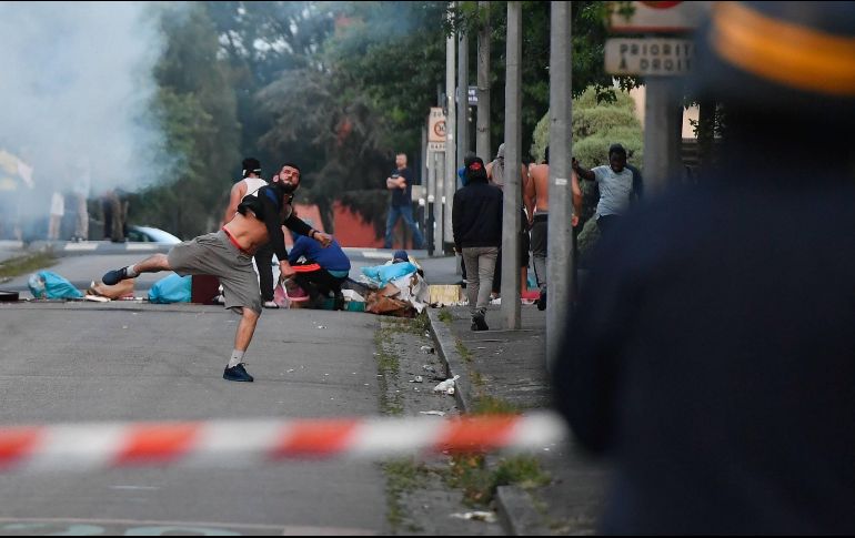 Varios manifestantes lanzan piedras a los agentes antidisturbios, quienes respondieron lanzando gases lacrimógenos. EFE/F. Dubray
