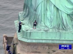 La mujer, identificada como Theresa Okoumou, sube al monumento en protesta por la separación de familias inmigrantes. AP