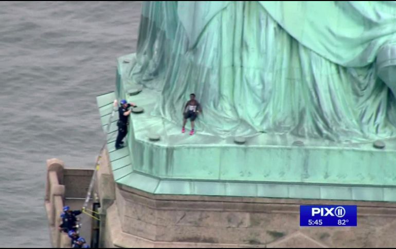 La mujer, identificada como Theresa Okoumou, sube al monumento en protesta por la separación de familias inmigrantes. AP