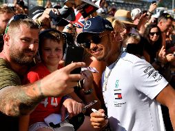 El piloto de Mercedes, Lewis Hamilton, convive con aficionados en el Circuito de Silverstone, previo al inicio del GP de Gran Bretaña. AFP/A. Isakovic