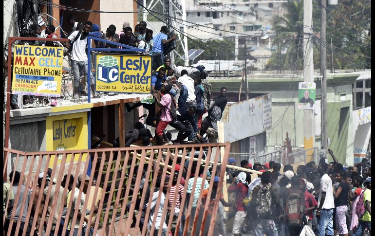 Habitantes saquean tiendas en Delmas, Haití, en el marco de protestas contra los altos precios del combustible. AFP/H. Retamal