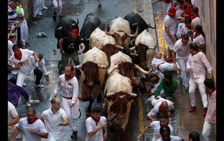Corredores y toros en el segundo encierro de los Sanfermines 2018, donde la lluvia y un toro rezagado desde Santo Domingo han caracterizado la carrera en Pamplona, España. EFE/V. López