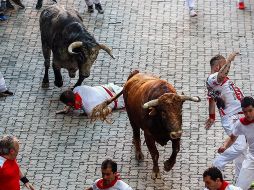 Varios mozos corren ante dos toros de la ganadería gaditana de Cebada Gago durante el tercer encierro de los Sanfermines 2018. EFE/R. Jiménez