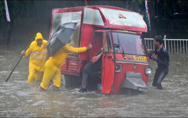 Policías empujan un vehículo de tres ruedas tras inundaciones en Bombay, India, debido a la temporada de monzones. AP/R. Maqbool