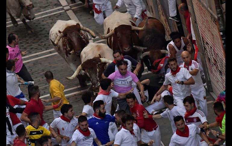 Toros de Cebada Gago pasan junto a asistentes al tercer encierro de la Feria de San Fermín, en Pamplona, España. AP/A. Barrientos