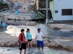 Residentes caminan por la zona devastada por fuertes lluvias en la ciudad de Mabi en Kurashiki, Prefectura de Okayama. EFE/JIJI