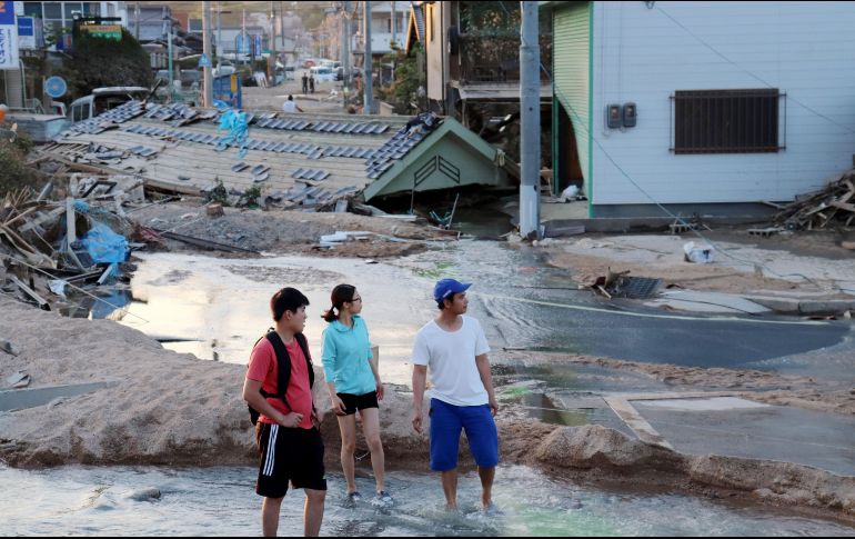 Residentes caminan por la zona devastada por fuertes lluvias en la ciudad de Mabi en Kurashiki, Prefectura de Okayama. EFE/JIJI