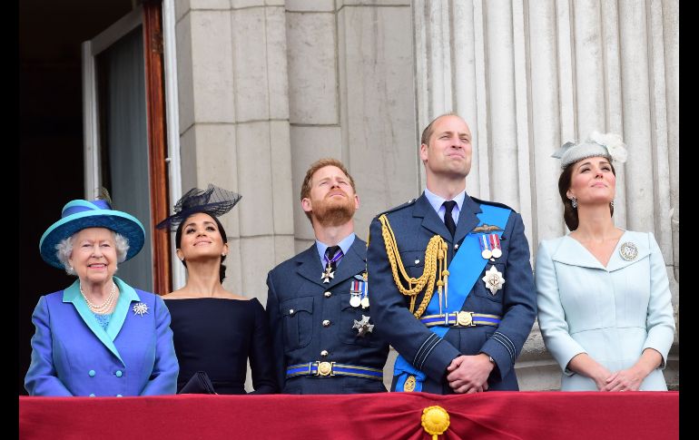 La reina Isabel II, los duques de Sussex Meghan y el príncipe Enrique, y los duques de Cambridge Guillermo y Catalina contemplan desde un balcón del palacio de Buckingham aviones de la Real Fuerza Aérea, durante una ceremonia en Londres por el centenario de la RAF. AFP/P. Grover