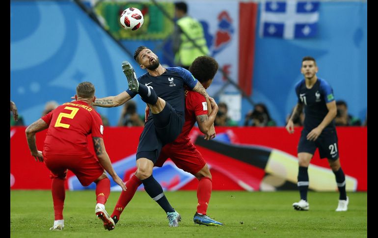 El francés Olivier Giroud (c) patea un balón junto al belga Toby Alderweireld. AFP/O. Andersen