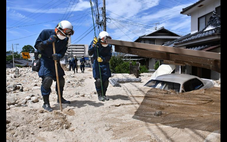 Policías usan palos en una operación de búsqueda en una zona cubierta de lodo en Kure, Japón. El país sigue tratando de contener los efectos de las lluvias torrenciales registradas desde el pasado jueves, que han dejado al menos 179 muertos. AP/Kyodo News/S.  Nishizume