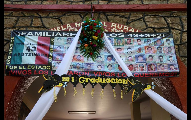 Un arreglo floral sobre un cartel con las imágenes de los 43 desaparecidos fue colocado en la Escuela Normal Rural de Ayotzinapa. EFE/F. Meza