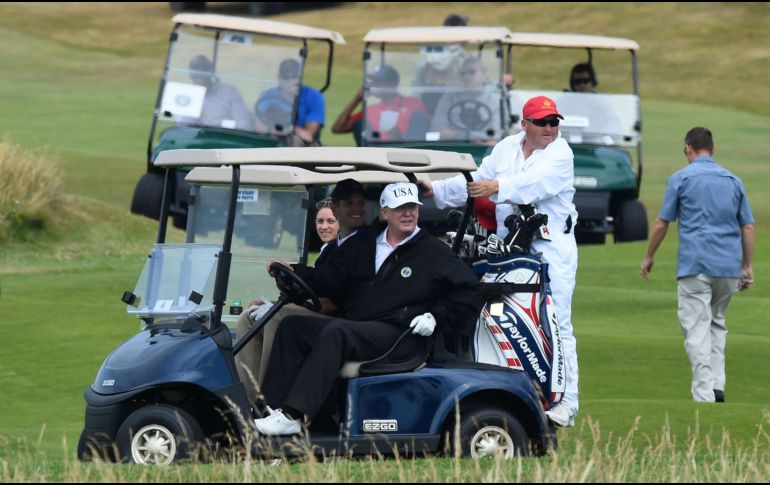 Trump se pasea con el carro de golf por el campo, ubicado frente a la costa suroeste de Ayrshire, luciendo una gorra blanca. AFP / A. Buchanan