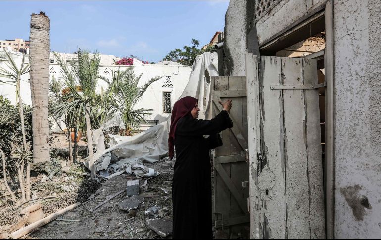 Una mujer inspecciona los daños ocasionados por los bombardeos. AFP/M. Hams