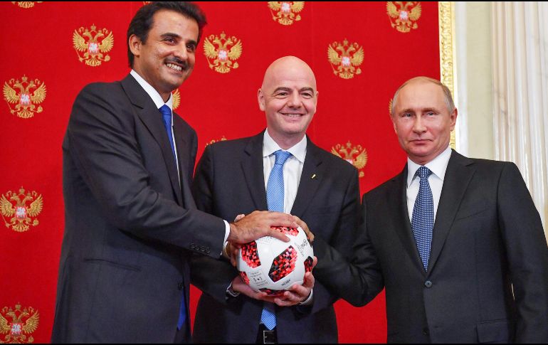 El presidente de la FIFA y el del país sede se unen para hacer entrega la copa de oro y malaquita. AFP / Y. Kadobnov