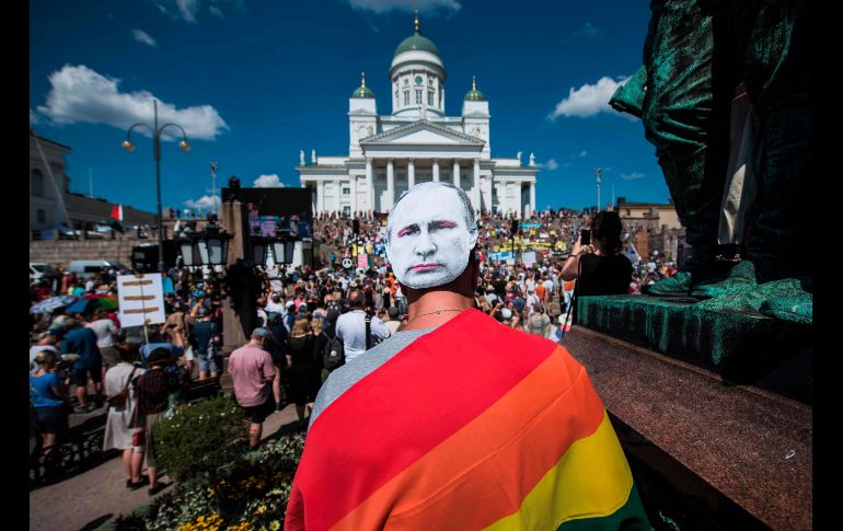 Un manifestante porta una máscara con la imagen del presidente ruso Vladimir Putin en Helsinki, Finlandia, durante una marcha en defensa de los derechos humanos, la libertad de expresión y la democracia, previa a la cumbre entre Putin y el mandatario estadounidense Donald Trump. AFP/J. Nackstrand