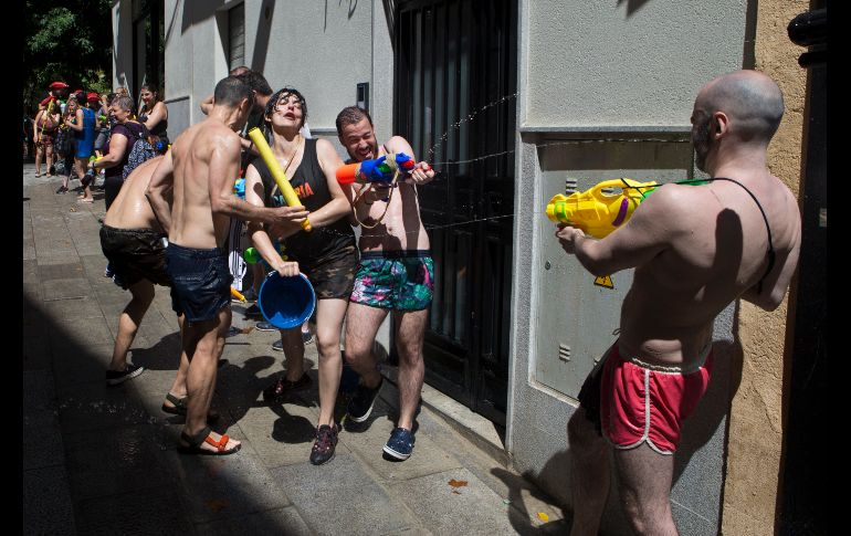 Personas participan en una guerra de agua anual en calles del vecindario de Vallecas en Madrid. AP/P. White