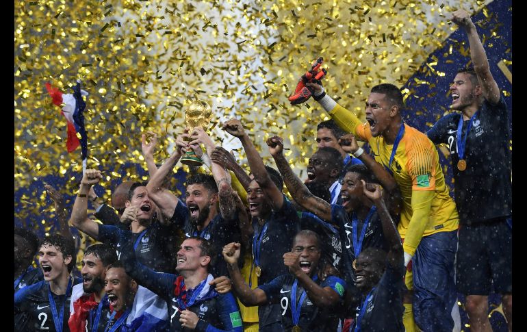 El equipo festeja con el trofeo de la Copa del Mundo.
