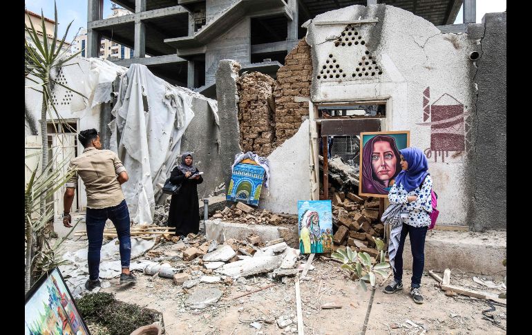 Artistas palestinos exhiben sus obras en el patio de un centro de artes y artesanías, dañado hace dos días durante bombardeos aéreos, en la Ciudad de Gaza. AFP/S. Khatib