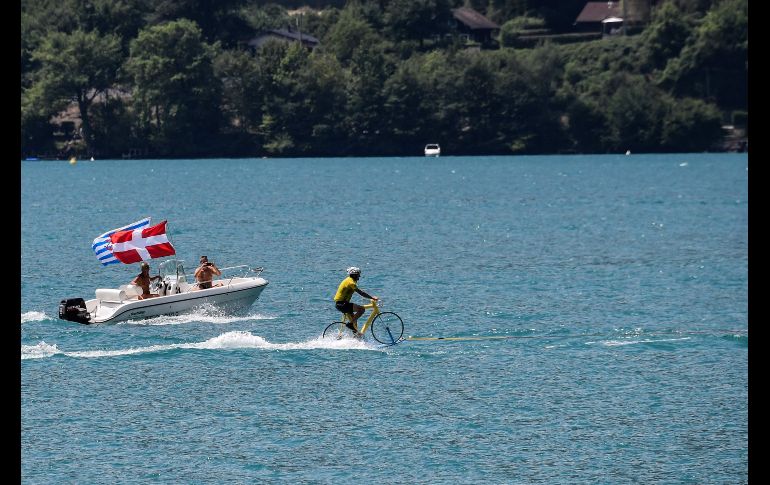 Un hombre practica esquí acuático sobre una bicicleta en un lago en la ciudad francesa de Annecy. AFP/J. Pachoud