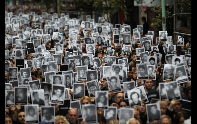 Cientos de personas levantan las fotografías de las 85 víctimas del atentado contra la mutua AMIA en 1994, durante una concentración en la sede de la Asociación de Mutuales Israelitas Argentinas , en Buenos Aires, Argentina. EFE/C. Ciudad