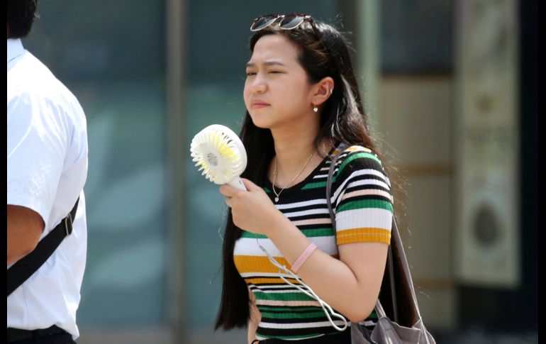 Una mujer usa un ventilador portátil en Tokio, donde se esperan temperaturas de hasta 37 grados. AP/K. Sasahara