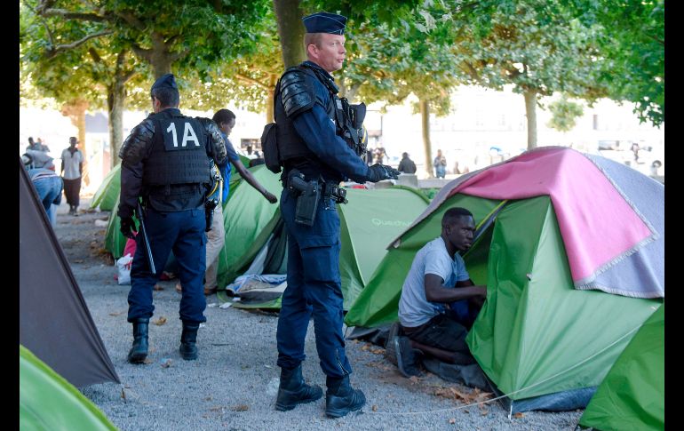 Policías evacuan un campamento de migrantes y refugiados en la plaza Daviais de Nantes, Francia. AFP/S. Salom
