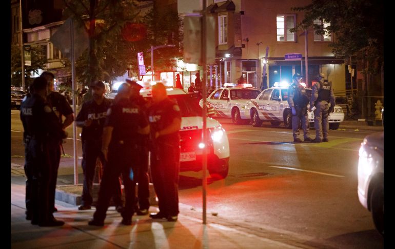Policías vigilan en la madrugada la escena de un tiroteo en Toronto, Canadá. Dos personas murieron el domingo por la noche en el tiroteo en el que el atacante murió, presuntamente, durante un intercambio de disparos con la policía. AFP/C. Burston